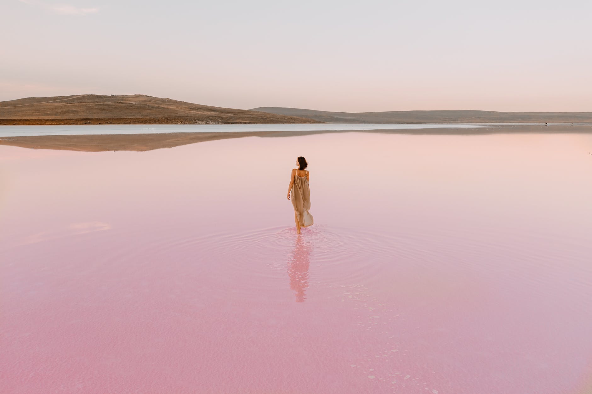 woman walking in pink water of a lake